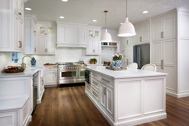 Inspiration for a timeless eat-in kitchen remodel in Other with a farmhouse sink, flat-panel cabinets, white cabinets, quartz countertops, white backsplash, stainless steel appliances, an island and white countertops
