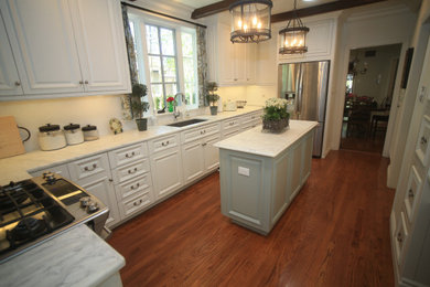 Example of a mid-sized classic galley dark wood floor eat-in kitchen design in Austin with raised-panel cabinets, white cabinets, marble countertops, white backsplash, ceramic backsplash, stainless steel appliances, an island and white countertops