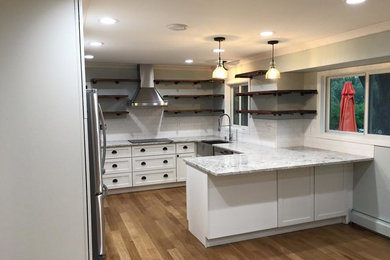 他の地域にあるトランジショナルスタイルのおしゃれなキッチン (シェーカースタイル扉のキャビネット、白いキャビネット、シルバーの調理設備) の写真