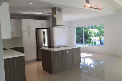 マイアミにある高級な広いトランジショナルスタイルのおしゃれなキッチン (フラットパネル扉のキャビネット、白いキャビネット、シルバーの調理設備、リノリウムの床) の写真
