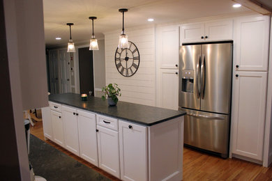 Inspiration for a mid-sized timeless galley light wood floor eat-in kitchen remodel in Providence with a farmhouse sink, recessed-panel cabinets, white cabinets, granite countertops, gray backsplash, marble backsplash, stainless steel appliances, an island and gray countertops