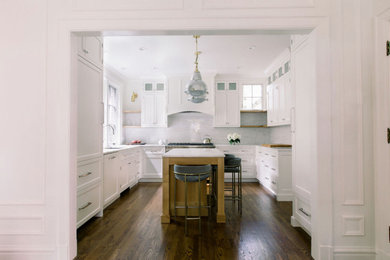 Kitchen - mid-sized traditional u-shaped dark wood floor kitchen idea in Chicago with an undermount sink, shaker cabinets, white cabinets, marble countertops, marble backsplash, stainless steel appliances, an island and white countertops