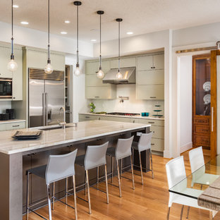 Design ideas for a medium sized contemporary l-shaped kitchen/diner in San Francisco with flat-panel cabinets, white splashback, stainless steel appliances, an island, grey cabinets, a submerged sink, marble worktops, ceramic splashback and light hardwood flooring.