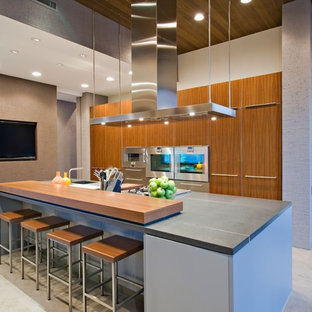 Photo of a large contemporary l-shaped open plan kitchen in San Francisco with an undermount sink, flat-panel cabinets, light wood cabinets, zinc benchtops, stainless steel appliances, porcelain floors, with island and beige floor.