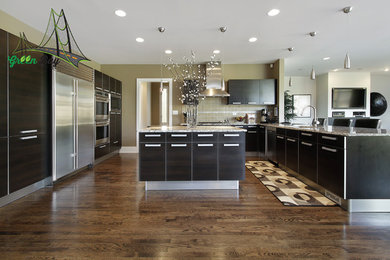 Example of a large trendy l-shaped medium tone wood floor eat-in kitchen design in San Francisco with an undermount sink, flat-panel cabinets, granite countertops, ceramic backsplash, stainless steel appliances, two islands, black cabinets and beige backsplash