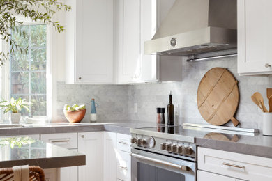 Large trendy l-shaped light wood floor and multicolored floor kitchen pantry photo in San Francisco with an undermount sink, shaker cabinets, white cabinets, quartz countertops, gray backsplash, marble backsplash, stainless steel appliances, an island and gray countertops