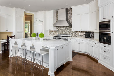 Example of a large minimalist painted wood floor and brown floor eat-in kitchen design in San Francisco with quartzite countertops, multicolored backsplash, glass tile backsplash, stainless steel appliances and an island