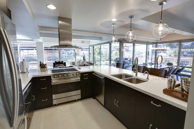 Eat-in kitchen - large modern u-shaped porcelain tile and beige floor eat-in kitchen idea in San Diego with a double-bowl sink, flat-panel cabinets, black cabinets, quartz countertops, stainless steel appliances, a peninsula and white countertops
