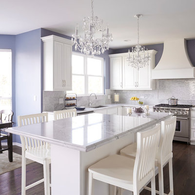 Example of a large classic u-shaped dark wood floor and brown floor eat-in kitchen design in Chicago with an undermount sink, raised-panel cabinets, white cabinets, quartzite countertops, gray backsplash, stone tile backsplash, stainless steel appliances and an island