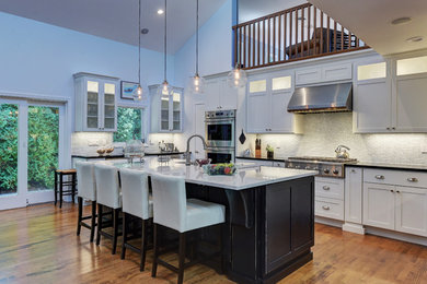 Eat-in kitchen - mid-sized contemporary l-shaped medium tone wood floor and brown floor eat-in kitchen idea in New York with a farmhouse sink, shaker cabinets, white cabinets, quartzite countertops, gray backsplash, glass tile backsplash, stainless steel appliances and an island