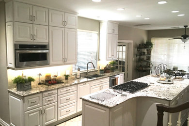 Foto de cocina campestre de tamaño medio con armarios con paneles con relieve, puertas de armario blancas, encimera de granito y una isla