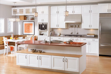 Medium sized contemporary galley kitchen/diner in Louisville with a built-in sink, shaker cabinets, white cabinets, laminate countertops, stainless steel appliances, light hardwood flooring and an island.