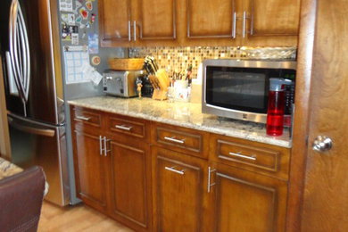 Example of a mid-sized l-shaped cork floor enclosed kitchen design in Other with an undermount sink, quartzite countertops, multicolored backsplash, stainless steel appliances and a peninsula