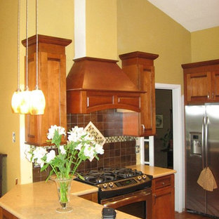 Design ideas for a mid-sized arts and crafts u-shaped separate kitchen in Dallas with an undermount sink, recessed-panel cabinets, medium wood cabinets, limestone benchtops, metallic splashback, metal splashback, stainless steel appliances, medium hardwood floors, a peninsula, brown floor and beige benchtop.