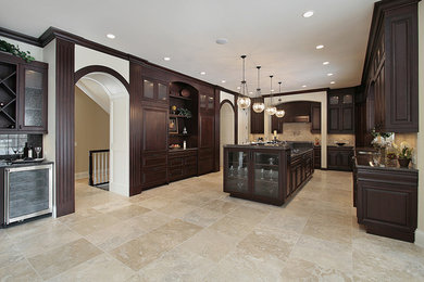 Large elegant u-shaped ceramic tile and beige floor enclosed kitchen photo in Orange County with raised-panel cabinets, dark wood cabinets, granite countertops, an island, brown backsplash, ceramic backsplash, stainless steel appliances and a double-bowl sink