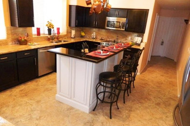 Mid-sized elegant single-wall vinyl floor and beige floor open concept kitchen photo in Phoenix with quartzite countertops, multicolored backsplash, an island, a double-bowl sink, shaker cabinets, black cabinets, stone slab backsplash and stainless steel appliances