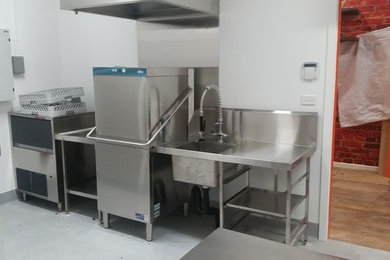 Esempio di una cucina parallela moderna di medie dimensioni con lavello a vasca singola, top in acciaio inossidabile, paraspruzzi a effetto metallico, elettrodomestici in acciaio inossidabile e pavimento in vinile