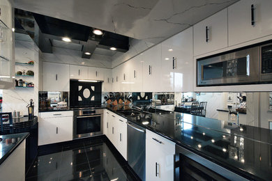 ワシントンD.C.にある広いコンテンポラリースタイルのおしゃれなII型キッチン (白いキャビネット、御影石カウンター、ミラータイルのキッチンパネル、シルバーの調理設備) の写真
