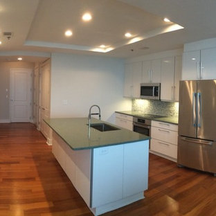 Design ideas for a modern open plan kitchen in Atlanta with an undermount sink, flat-panel cabinets, white cabinets, quartz benchtops, green splashback, mosaic tile splashback, stainless steel appliances, laminate floors and green benchtop.