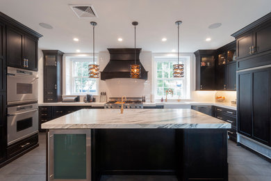 Eat-in kitchen - large transitional u-shaped porcelain tile and black floor eat-in kitchen idea in Philadelphia with a farmhouse sink, shaker cabinets, black cabinets, marble countertops, white backsplash, subway tile backsplash, stainless steel appliances, an island and white countertops