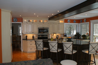 Enclosed kitchen - traditional u-shaped enclosed kitchen idea in Ottawa with a double-bowl sink, raised-panel cabinets, beige cabinets, granite countertops, beige backsplash, cement tile backsplash, stainless steel appliances and an island