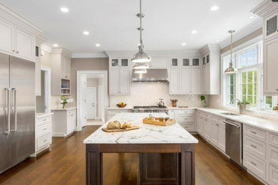 Example of a large medium tone wood floor kitchen design in New York with shaker cabinets, white cabinets, quartzite countertops, no island and white countertops