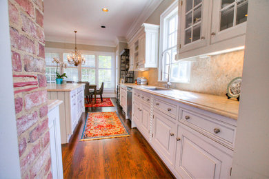 Inspiration for a mid-sized transitional l-shaped medium tone wood floor eat-in kitchen remodel in Charlotte with an island, raised-panel cabinets, white cabinets, an undermount sink, marble countertops, multicolored backsplash, stone slab backsplash and stainless steel appliances