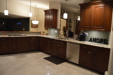 Example of a large transitional u-shaped ceramic tile eat-in kitchen design in Other with a double-bowl sink, raised-panel cabinets, dark wood cabinets, granite countertops, stainless steel appliances and no island