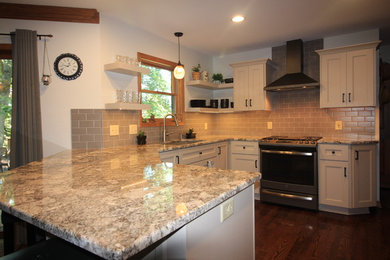 Inredning av ett klassiskt grå grått kök, med en undermonterad diskho, luckor med infälld panel, grå skåp, granitbänkskiva, grått stänkskydd, stänkskydd i keramik, färgglada vitvaror, mellanmörkt trägolv, en köksö och brunt golv