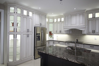 Inspiration for a large timeless l-shaped kitchen remodel in Toronto with an undermount sink, raised-panel cabinets, white cabinets, gray backsplash, stainless steel appliances and an island