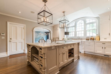 Open concept kitchen - mid-sized transitional l-shaped medium tone wood floor and brown floor open concept kitchen idea in New York with a farmhouse sink, beaded inset cabinets, white cabinets, marble countertops and an island