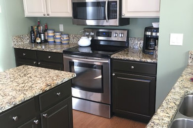 Example of a mid-sized classic l-shaped medium tone wood floor kitchen pantry design in Denver with a double-bowl sink, raised-panel cabinets, light wood cabinets, granite countertops, green backsplash, stainless steel appliances and an island