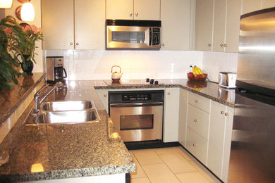 Exempel på ett litet klassiskt kök, med en dubbel diskho, släta luckor, grå skåp, granitbänkskiva, vitt stänkskydd, stänkskydd i keramik, rostfria vitvaror och klinkergolv i keramik