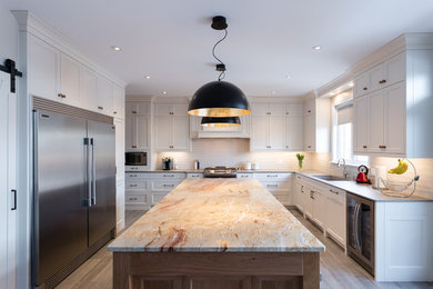 Kitchen - large kitchen idea in Ottawa with white cabinets, white backsplash, stainless steel appliances and an island