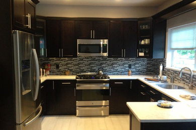 Example of a trendy u-shaped eat-in kitchen design in New York with an undermount sink, shaker cabinets, dark wood cabinets, granite countertops and stainless steel appliances