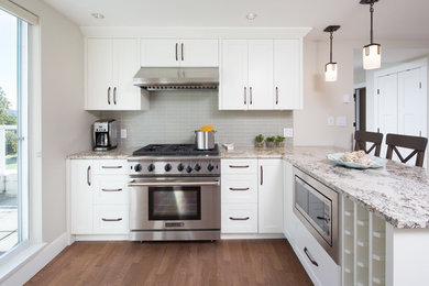 Inspiration for a mid-sized modern l-shaped medium tone wood floor and brown floor enclosed kitchen remodel in Other with shaker cabinets, white cabinets, white backsplash, glass tile backsplash, stainless steel appliances, no island and multicolored countertops