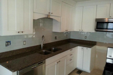 Example of a kitchen design in Other with white cabinets, granite countertops and stainless steel appliances