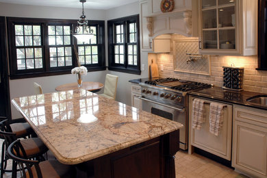 Enclosed kitchen - large traditional l-shaped ceramic tile and beige floor enclosed kitchen idea in Minneapolis with an undermount sink, recessed-panel cabinets, white cabinets, granite countertops, beige backsplash, ceramic backsplash, white appliances and an island