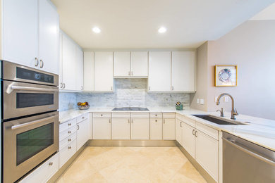 Inspiration for a small transitional u-shaped marble floor eat-in kitchen remodel in Miami with an undermount sink, flat-panel cabinets, white cabinets, marble countertops, white backsplash, stone tile backsplash, stainless steel appliances and a peninsula