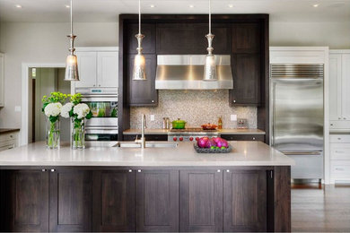 Example of a mid-sized transitional l-shaped light wood floor eat-in kitchen design in Toronto with an undermount sink, shaker cabinets, granite countertops, metallic backsplash, mosaic tile backsplash, stainless steel appliances, an island and white cabinets