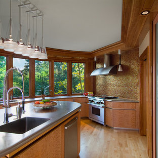 Design ideas for a contemporary kitchen in Cincinnati with stainless steel benchtops, an integrated sink, metallic splashback, mosaic tile splashback, flat-panel cabinets, medium wood cabinets and stainless steel appliances.