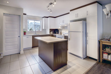 モントリオールにある低価格の中くらいなコンテンポラリースタイルのおしゃれなキッチン (ドロップインシンク、フラットパネル扉のキャビネット、白いキャビネット、ラミネートカウンター、ベージュキッチンパネル、白い調理設備、磁器タイルの床) の写真