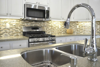 Example of a mid-sized classic u-shaped eat-in kitchen design in San Diego with a double-bowl sink, recessed-panel cabinets, white cabinets, granite countertops, multicolored backsplash, matchstick tile backsplash, stainless steel appliances and an island
