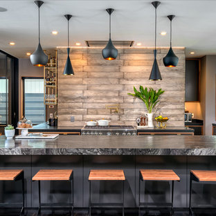 Modelo de cocina en U, contemporánea, grande, abierta, con fregadero bajoencimera, armarios con paneles lisos, puertas de armario grises, encimera de mármol, salpicadero marrón, salpicadero de madera, electrodomésticos de acero inoxidable y una isla
