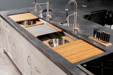Immagine di una cucina chic con lavello sottopiano, ante a filo, ante bianche, top in cemento e parquet chiaro