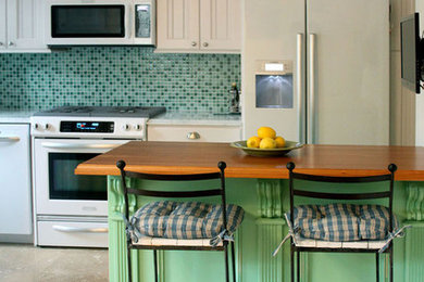 ワシントンD.C.にある小さなカントリー風のおしゃれなキッチン (アンダーカウンターシンク、緑のキッチンパネル、ガラスタイルのキッチンパネル、白い調理設備、ベージュの床、シェーカースタイル扉のキャビネット、白いキャビネット、大理石カウンター) の写真