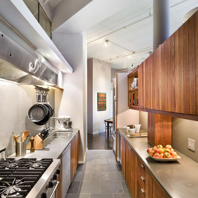Enclosed kitchen - industrial galley slate floor enclosed kitchen idea in New York with stainless steel appliances, an undermount sink, flat-panel cabinets and medium tone wood cabinets