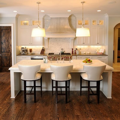 Inspiration for a mid-sized timeless single-wall dark wood floor eat-in kitchen remodel in Nashville with white cabinets, paneled appliances, recessed-panel cabinets, marble countertops, an island, a farmhouse sink, white backsplash and stone tile backsplash