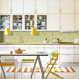 Photo of a mid-sized modern single-wall eat-in kitchen in Gold Coast - Tweed with white cabinets, yellow splashback, a double-bowl sink, glass tile splashback, glass-front cabinets, laminate benchtops, white appliances, porcelain floors, no island, white floor and brown benchtop.