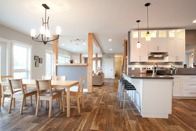Eat-in kitchen - mid-sized traditional u-shaped vinyl floor eat-in kitchen idea in Vancouver with a drop-in sink, shaker cabinets, white cabinets, laminate countertops, gray backsplash, ceramic backsplash, stainless steel appliances and a peninsula